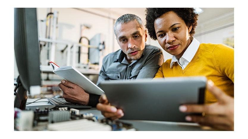 Two coworkers in office using tablets