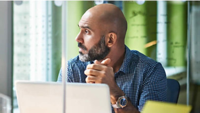 Man in front of computer looking to his left side