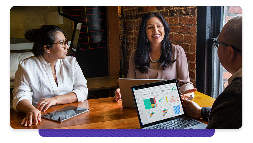 Three people at a table with laptops