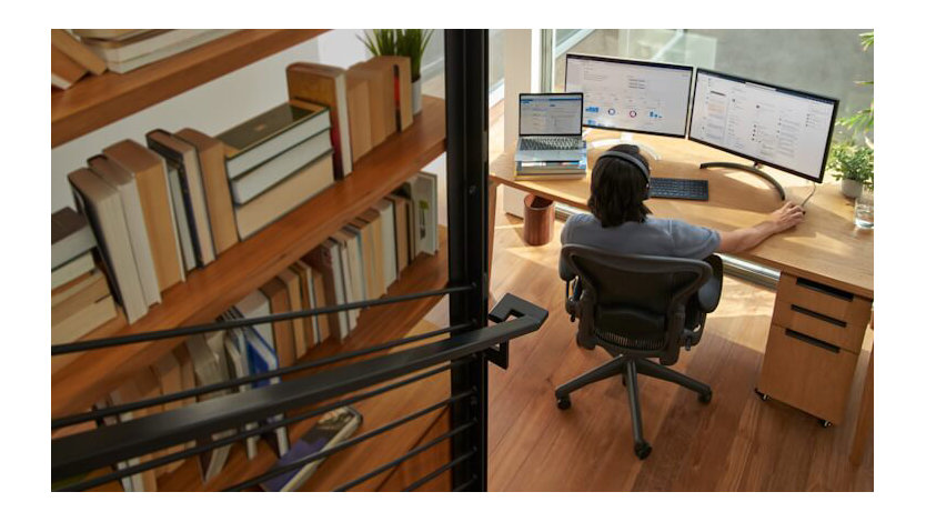 A Microsoft employee works at their desk in their home office.