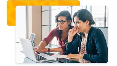 Two people sharing a laptop while having a discussion