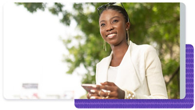 Person looking off into the distance while walking outside holding a mobile phone