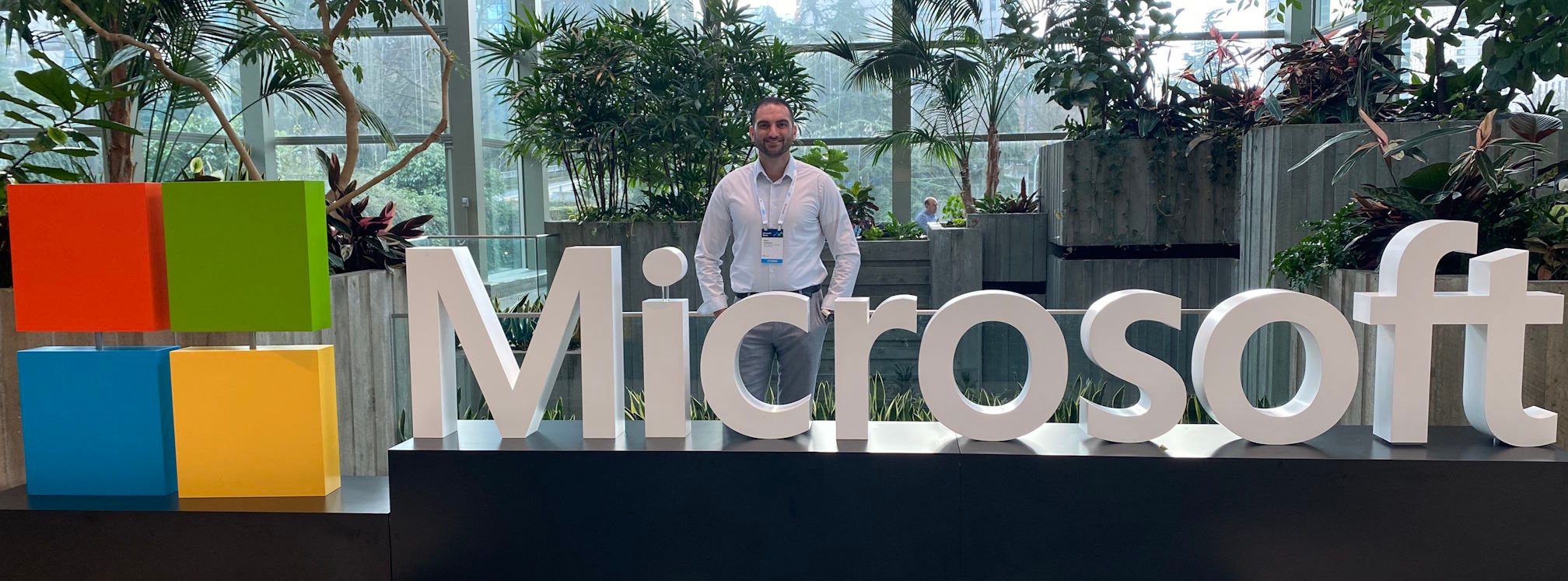 Sam Istephan stood behind a large Microsoft sign at a convention