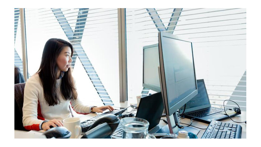 A Microsoft employee works at her desk in an open space working arrangement.