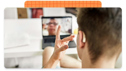 View of a person from behind, using sign language directed at their laptop