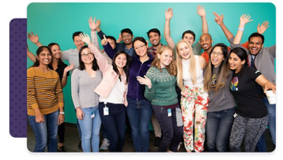 A large group of Microsoft employees standing together, smiling and waving for a photo
