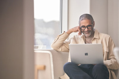 Man using his Surface laptop on a couch.