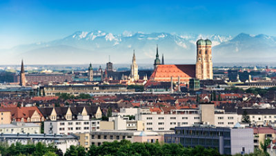 The Munich skyline with mountains in the background.