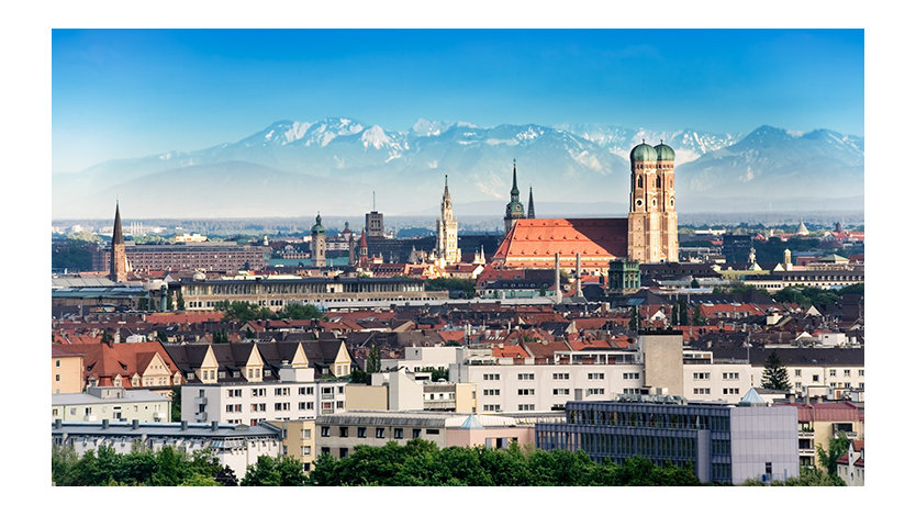 The Munich skyline with mountains in the background.