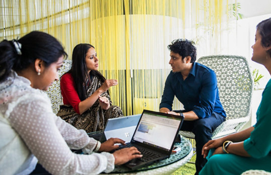 A group of four lawyers sitting and talking in an office.