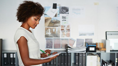 A female worker taking notes on a notepad.