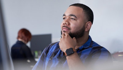 Man with his hand to his chin thinking and looking up.