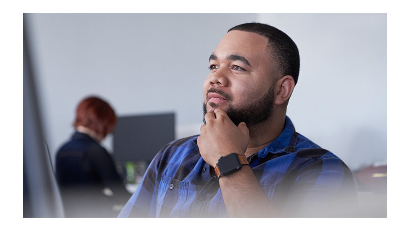 Man with his hand to his chin thinking and looking up.