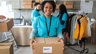 A young volunteer holding a box marked donate