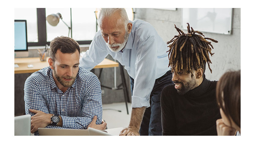 A group of coworkers in discussion in office setting