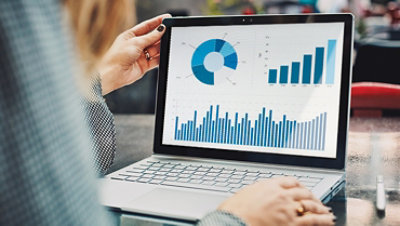 Profissional mobile usando um Surface Book e uma Caneta Surface visualizando um gráfico financeiro.