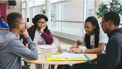 A group of young adults sitting around a table studying