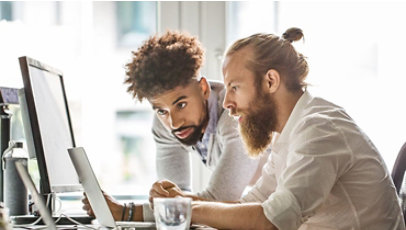 People in a office discussing work over a laptop.