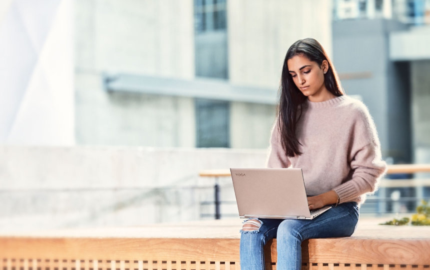 Woman working on her laptop, sitting outside 