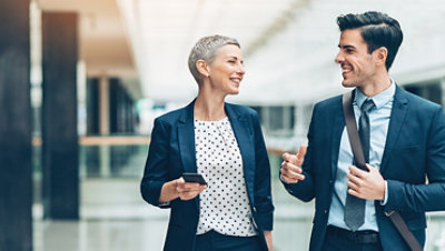 Two businesspersons walking together and talking.