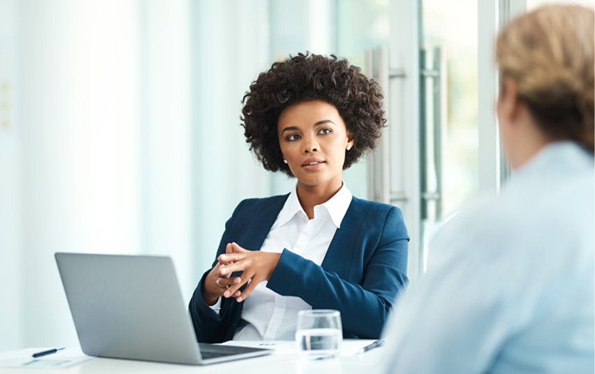 Businesswoman using her laptop while meeting with a client. 