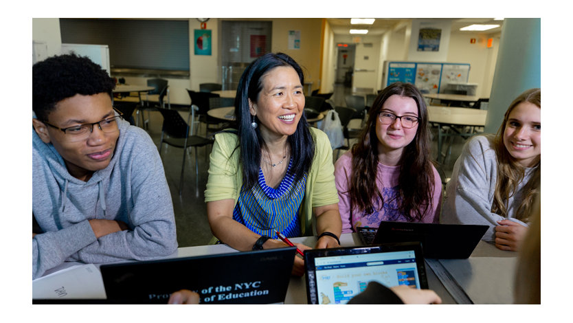 Teacher with group of students in a computer lab.