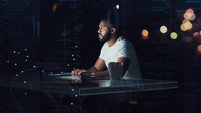 夜间，一位程序员正在办公室使用电脑工作。