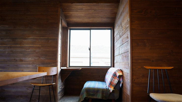 ソファと椅子が置かれ、テーブルなどの家具と堅木張りの床が備わった部屋。部屋には窓のある壁と天井があります。