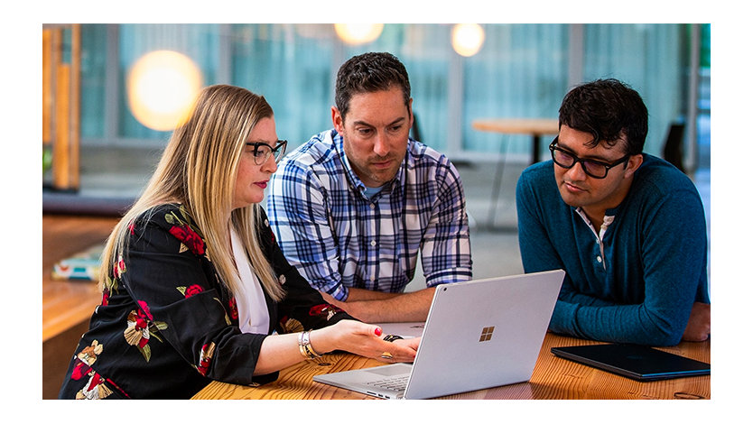 Three tech workers meeting in a common office space.