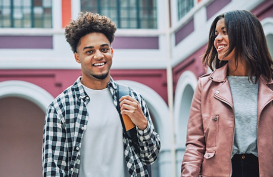 Two students in front of a building.