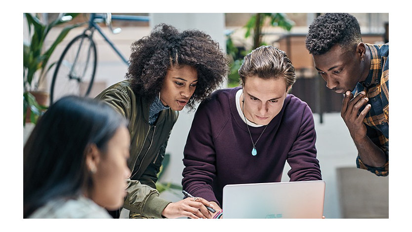 Group of people working together on a laptop.