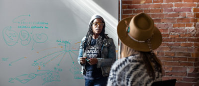 A man and woman sitting at a table with a laptop.
