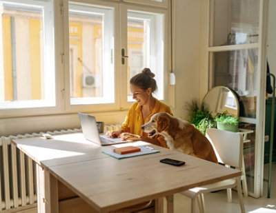A woman and dog looking at a computer.