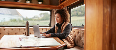 Osoba isteže nogu dok kleči na tlu u osunčanom predelu. Odevena je u majicu bez rukava