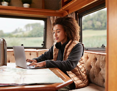 A woman sitting at a table using a laptop.