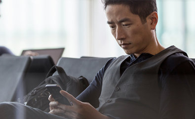 Uomo seduto che guarda il suo tablet.