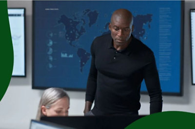 A person looking over a coworker's shoulder at their computer.