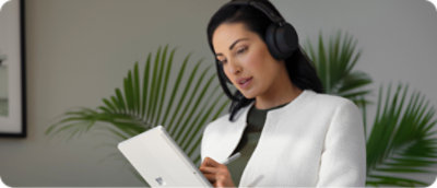 Egy fejhallgatót viselő személy digitális tollal ír egy táblagépre