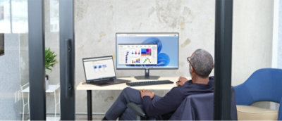 Un hombre sentado en un escritorio con un equipo que muestra un gráfico.