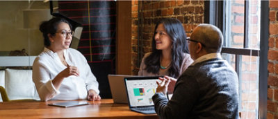 Group of people discussing while sitting and some of them are using a laptop.