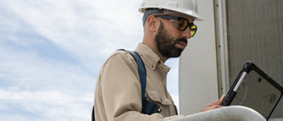 Un hombre con un casco usa un portátil