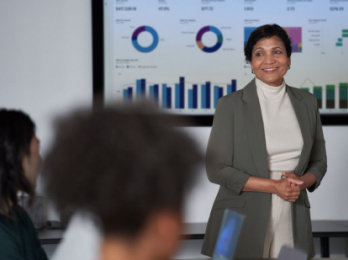 Una persona in piedi davanti a un grande schermo