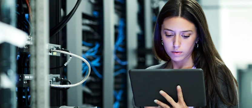 A woman using a tablet in a server room