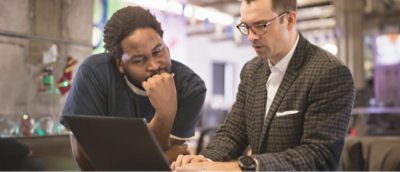 Twee personen die naar een computer kijken