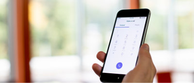 Personne tenant un téléphone avec une calculatrice dessus.