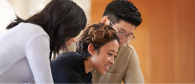 A group of people looking at a laptop.