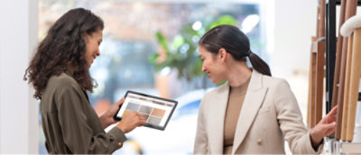 Een persoon die een tablet vasthoudt en een persoon die naar iets kijkt