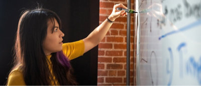 A woman writing on a whiteboard