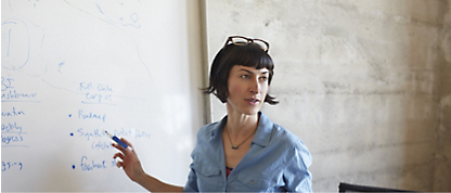 En kvinde står foran et whiteboard