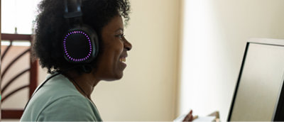 Femme avec casque travaillant sur un ordinateur.